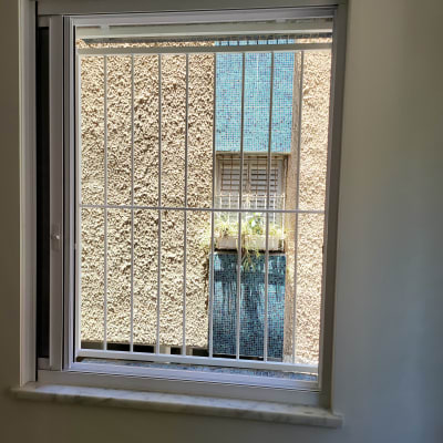 חלון עם מסגרת לבנה וסורגים לבנים