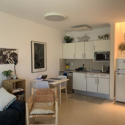 מטבח מודרני עם ארונות לבנים ומכשירי חשמל