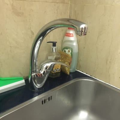 ברז נירוסטה מעל כיור מטבח עם סבון כלים