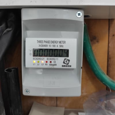 מונה חשמל תלת פאזי מותקן על קיר עץ