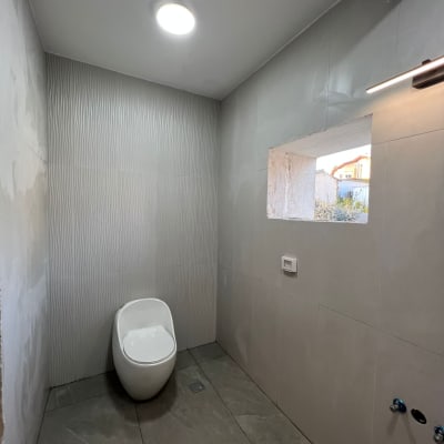 שירותים עם קיר אריחים, תאורה עגולה, חלון פתוח