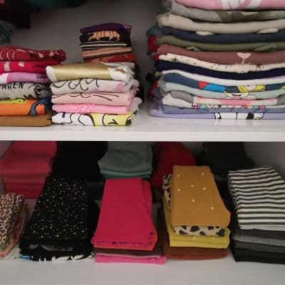 בגדים מקופלים בארון על מדפים מסודרים