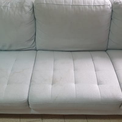 ספה עם כתמים ומברשת ניקוי מונחת עליה