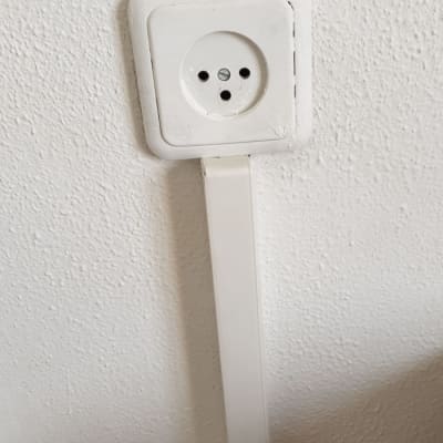 שקע חשמל עם כבל לבן על קיר