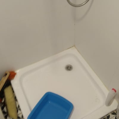 מגש כחול במקלחת עם צינור מים