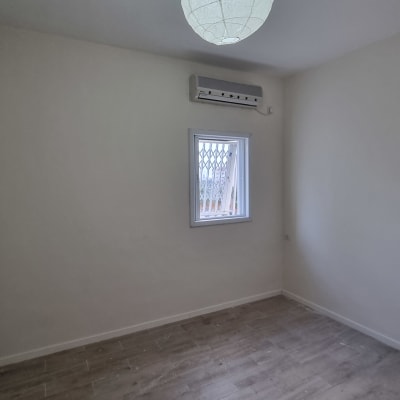 חדר עם קירות צבועים בלבן ותקרה לבנה