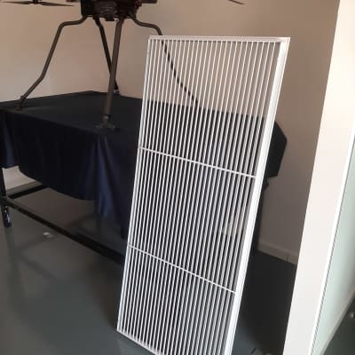 גריל מתכת לבן ליד רחפן שחור על שולחן