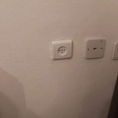 שקע חשמל ולוח תקשורת על קיר לבן