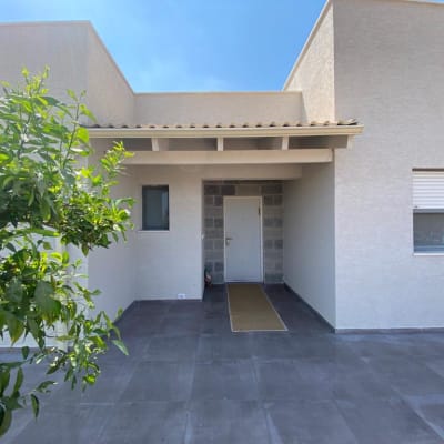 כניסה לבית עם דלת לבנה וריצוף אפור