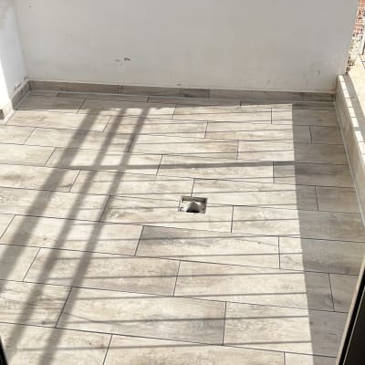 רצפת מרפסת עם אריחים ודלת זכוכית פתוחה