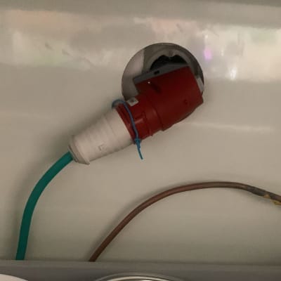 תקע חשמלי אדום מחובר לכבל ירוק