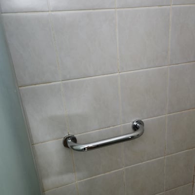 ידית אחיזה מתכתית מותקנת על קיר אריחים