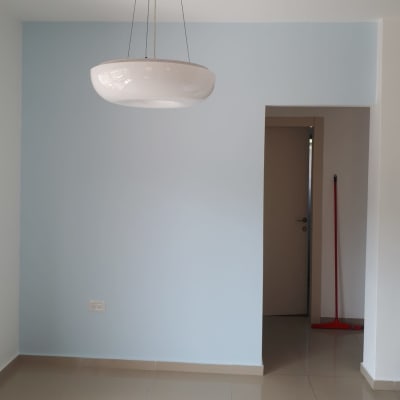 מטאטא אדום נשען על הקיר ליד דלת