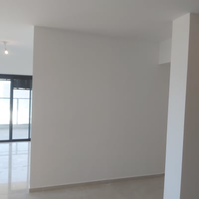 קיר גבס לבן בחדר ריק עם רצפת אריחים