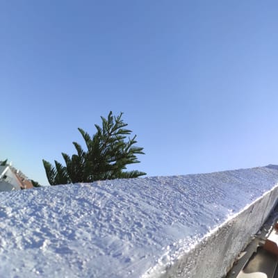 קיר אטום בציפוי מבריק תחת שמיים כחולים