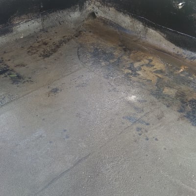 גג אטום בזפת עם סימני שחיקה ופינות כהות