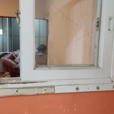 קיר צבוע בכתום עם חלון לבן ישן