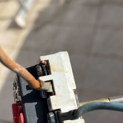 חיבורי כבלים למפסק חשמלי עם סימני חלודה