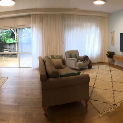 רצפת פרקט עץ בסלון מואר עם שטיחים ורהיטים