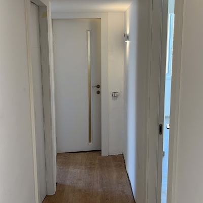 מסדרון עם דלתות לבנות ודלת זכוכית