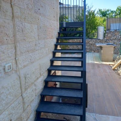 גרם מדרגות מתכת עם מעקה ברזל בצד ימין