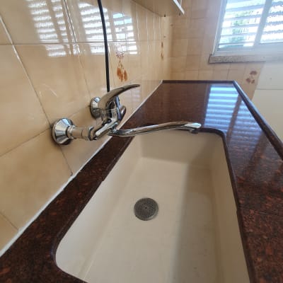 כיור מטבח עם ברז נירוסטה על משטח שיש