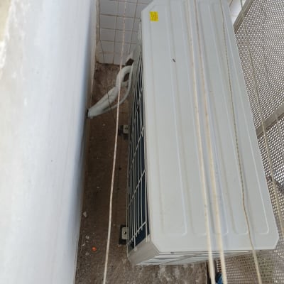 יחידת מזגן חיצונית מותקנת על קיר לבן