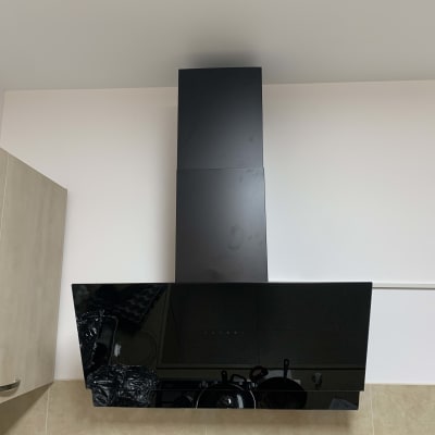 קולט אדים שחור מותקן על קיר מטבח