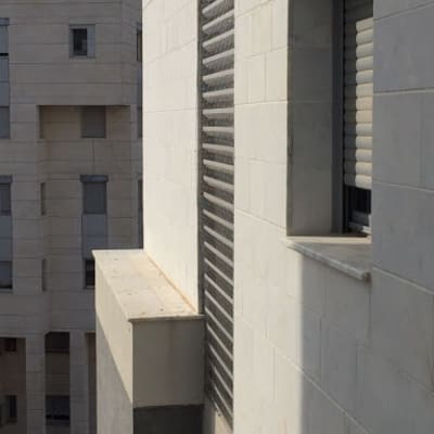 קיר בניין עם חלון ותריסים סגורים