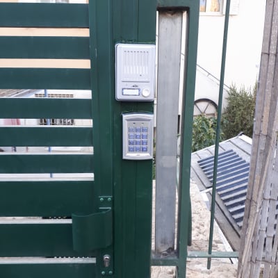 אינטרקום עם לוח מקשים על שער מתכת ירוק