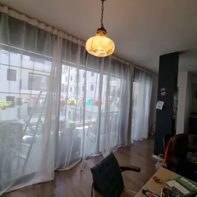 סולם מתכת ליד חלון עם וילון שקוף