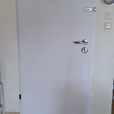 דלת לבנה עם ידית מתכת ובריח