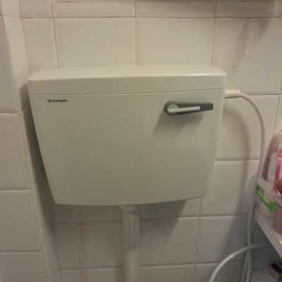 ניאגרה לבנה עם ידית מתכת בחדר אמבטיה