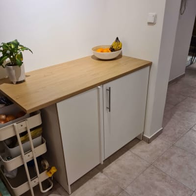 ארון מטבח עם ידיות מתכת על רצפת קרמיקה