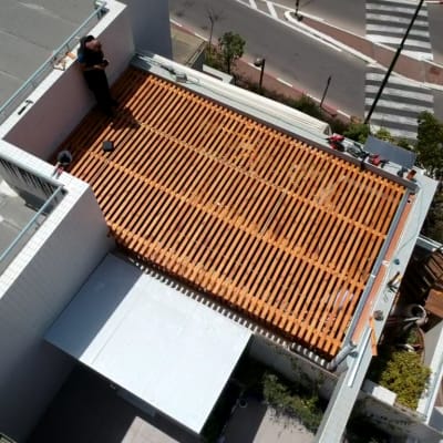 פרגולה מעץ על גג עם אדם עובד