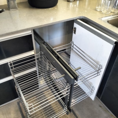 מגירות מתכת נשלפות במטבח עם כלים על השיש