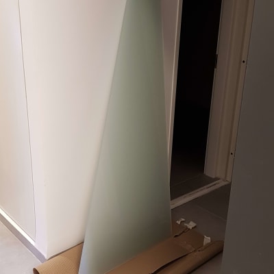 זכוכית משולשת מונחת על קרטון ברצפה