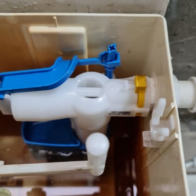 מנגנון פלסטיק לבן וכחול בתוך מיכל הדחה