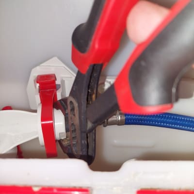 כלי עבודה אדום מתקן צינור כחול במערכת אינסטלציה