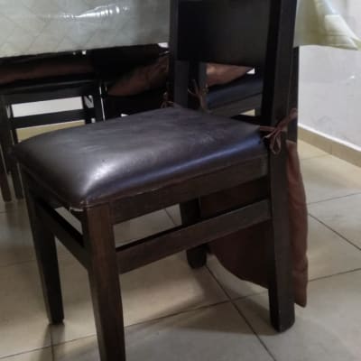 כרית חומה קשורה לכיסא עץ כהה