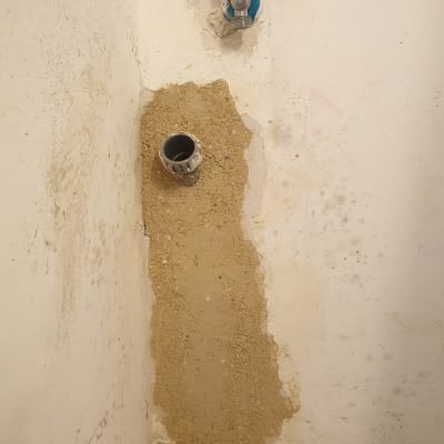 ברז מים וצינור בקיר עם טיח