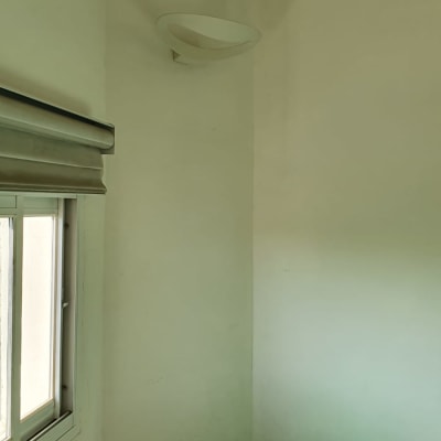 מנורת קיר לבנה ושקע חשמל על הקיר