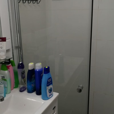 מקלחון זכוכית עם ידית מתכת בחדר אמבטיה