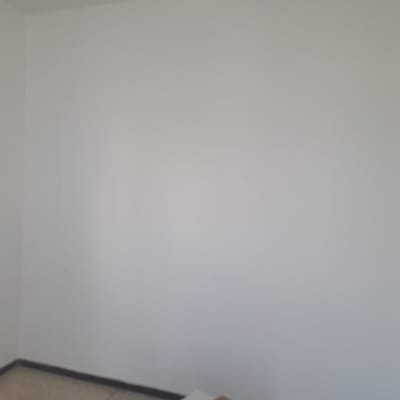 קיר צבוע בלבן עם מקל עץ בפינה