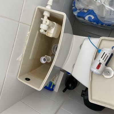 מיכל אסלה פתוח עם חלקי אינסטלציה גלויים