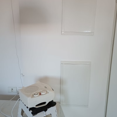 תנור חימום קטן על שרפרף פלסטיק לבן