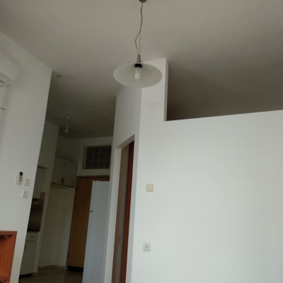 קיר לבן עם מנורה תלויה מהתקרה