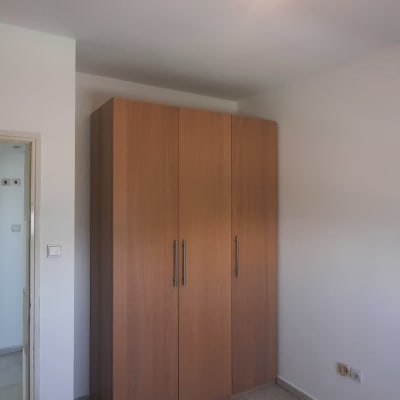 חדר ריק עם ארון עץ ודלת פתוחה