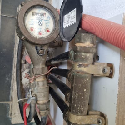 מונה מים עם צינורות וברז אדום