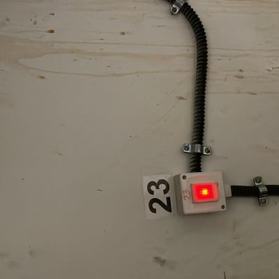 תיבת חשמל עם נורית אדומה דולקת על קיר